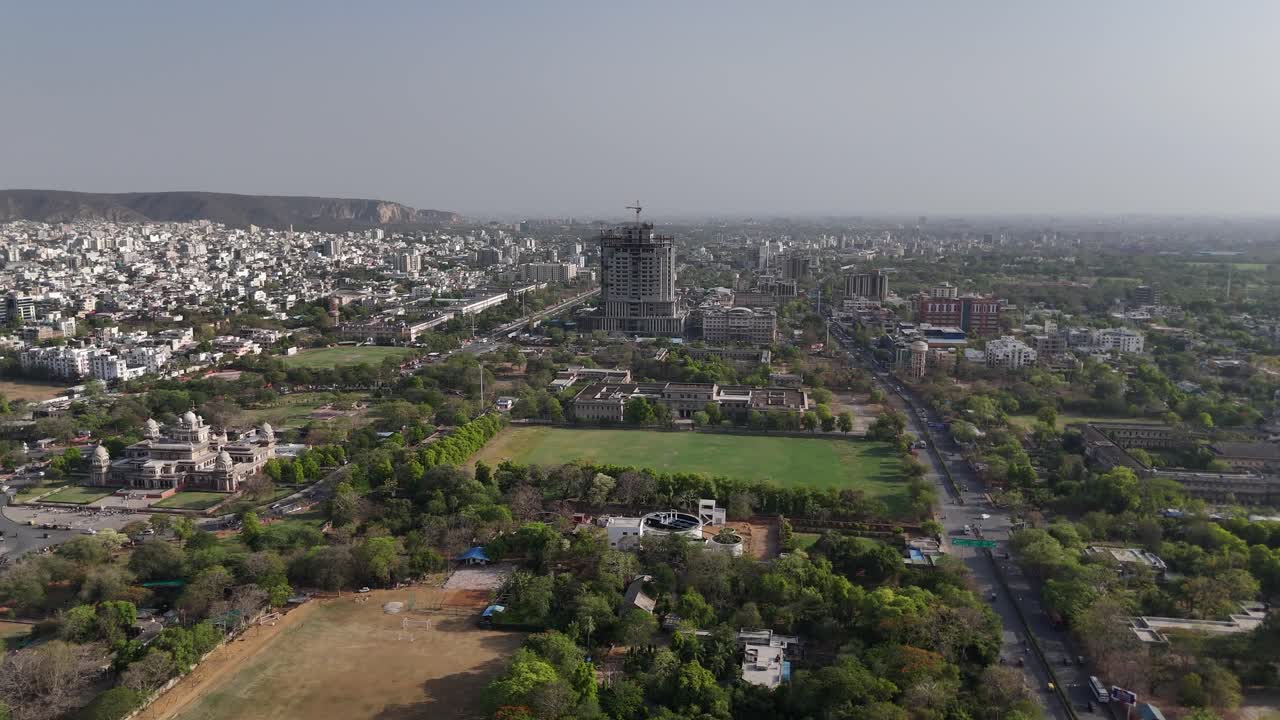 High-altitude shot capturing undercontruction buildign near surrounding hills.