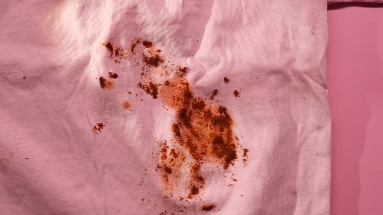 Close-up of a stubborn brown stain on a pink fabric