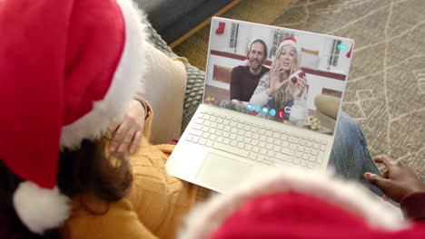 Dos-Parejas-Felices-Y-Diversas-Teniendo-Videollamada-Navideña-Con-Computadora-Portátil,-Cámara-Lenta