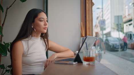 mujer trabajando en una tableta en un café