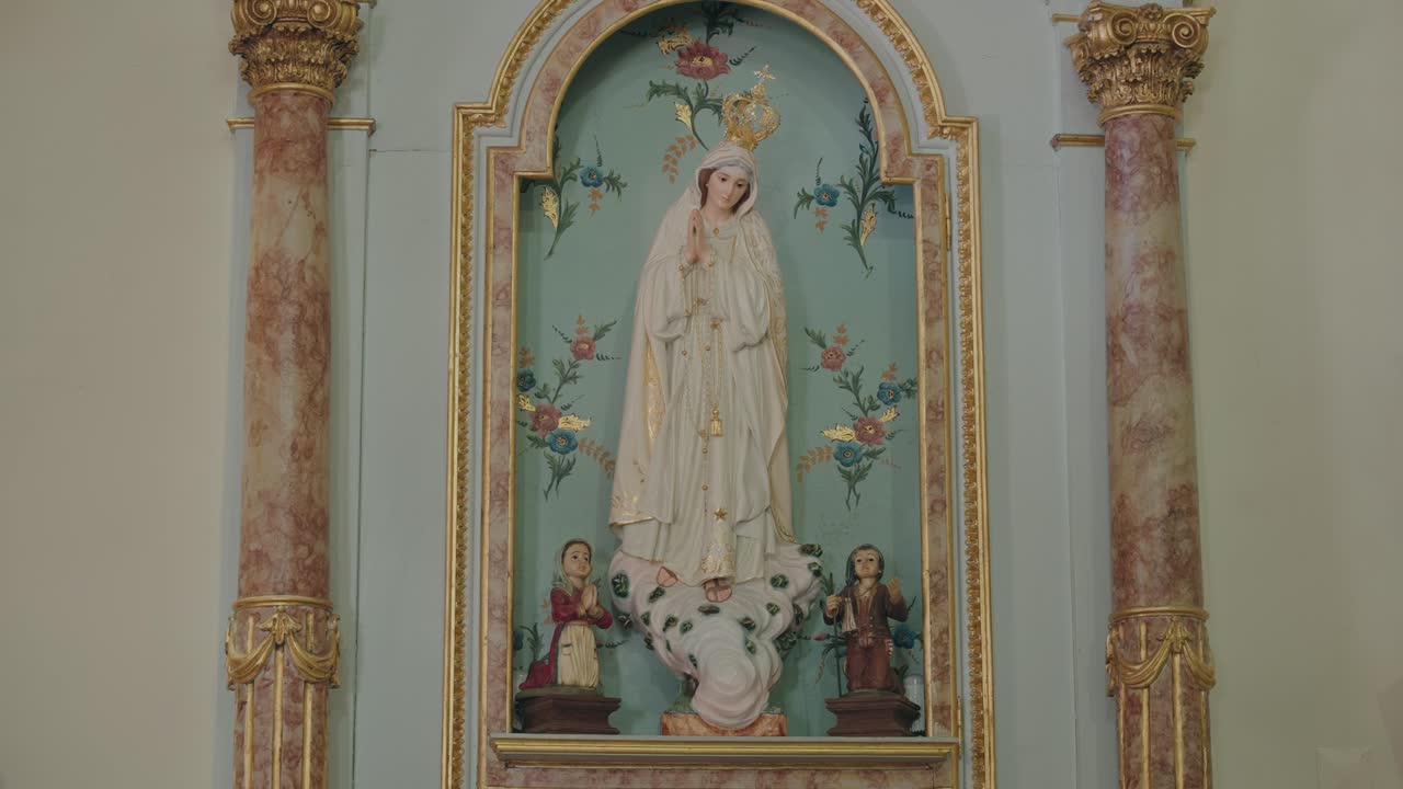 religious statue of our lady of fatima and children in decorated chapel