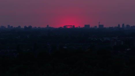 Die-Sonne-Ist-Fast-Hinter-Den-Silhouetten-Städtischer-Gebäude-Verschwunden