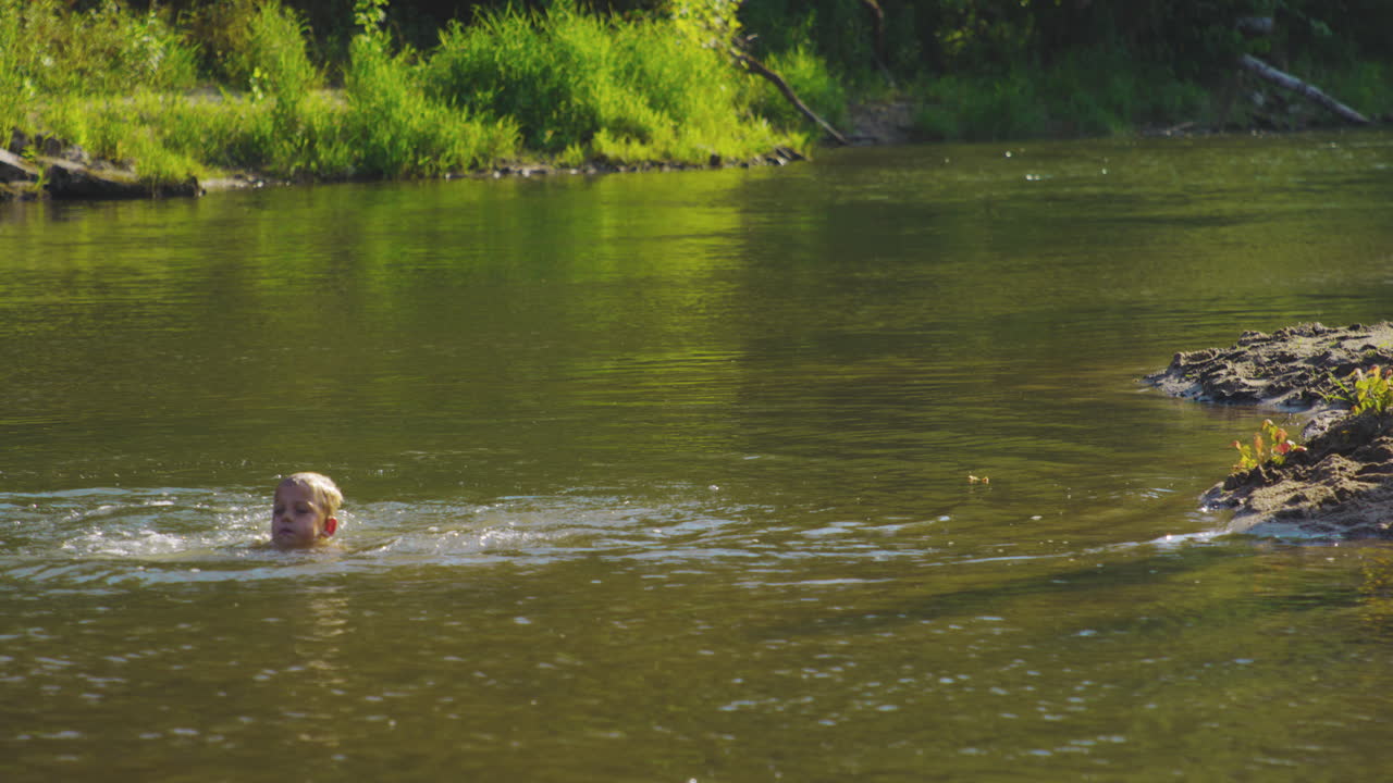 젊은 백인 소년 은 조용 한 호수 에서 수영 한다