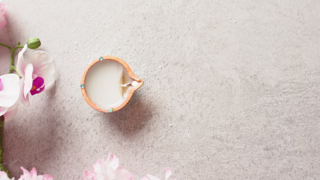 vela encendida celebrando diwali con espacio de copia y flores en fondo blanco