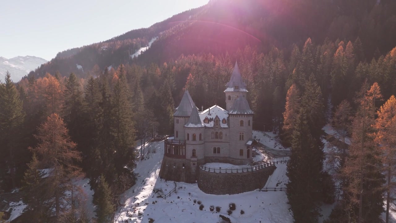 Widoki z drona Zamku Savoia w Gressoney, otoczonego zaśnieżonymi drzewami i magicznym zimowym krajobrazem.