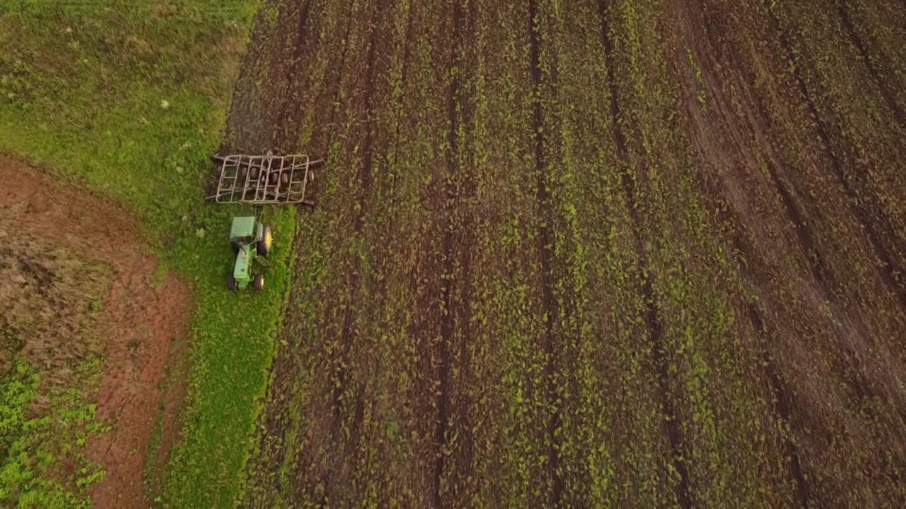 Tilling Tractor At Work On The Farmland In Monroe County, Michigan - aerial drone
