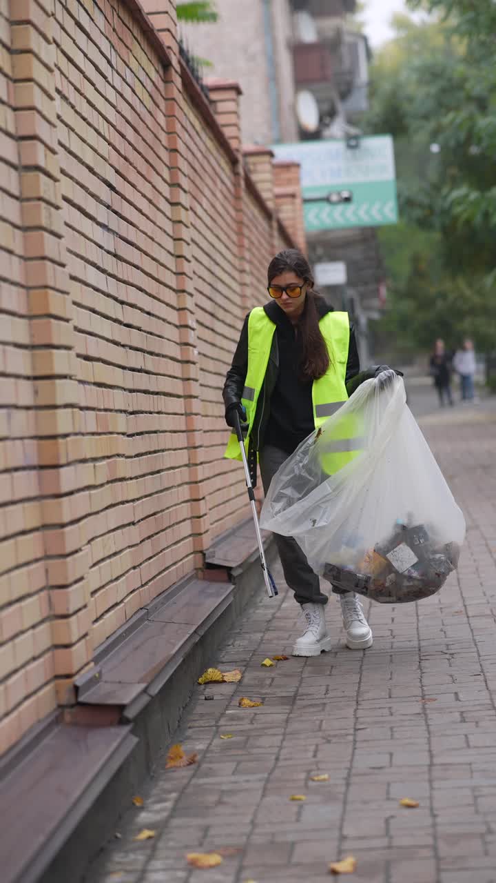 mujer limpiando la basura en la calle de la ciudad