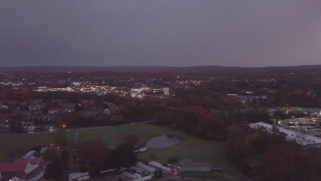 Zeitrafferaufnahme-Einer-Aufsteigenden-Drohne-Bei-Sonnenuntergang-In-Einer-Kleinstadt