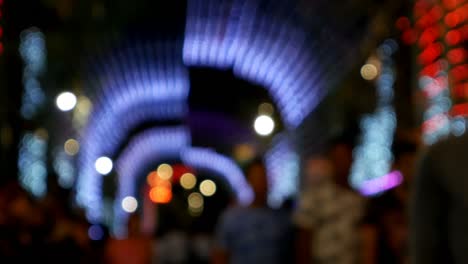 people walking street at night background, tunnel of blurred colorful bokeh light defocused background and textured for christmas