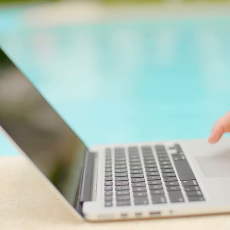 Woman-Working-on-Her-Laptop-in-Swimming-Pool-Area