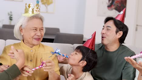 a family enjoys a lively birthday party with hats, whistles, and laughter in a cozy home setting