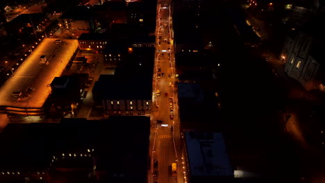 street of sherbrooke city illuminated with lights at nighttime in canada - aerial pullback