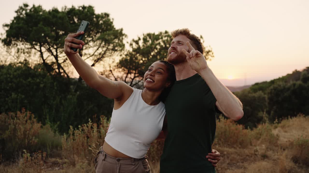 Una pareja tomando una selfie al atardecer