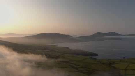 Early-morning-clouds-drift-over-the-mountains-in-Co-Kerry-Ireland-as-the-sun-shines-during-the-summer