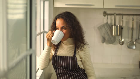 beautiful latin woman drinking coffee in kitchen