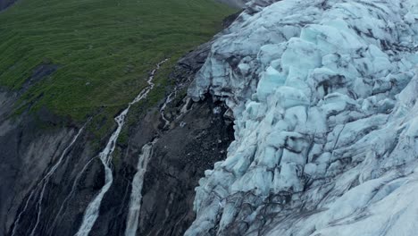 derretimiento del glaciar creando corrientes de agua fría que fluyen por la montaña, antena