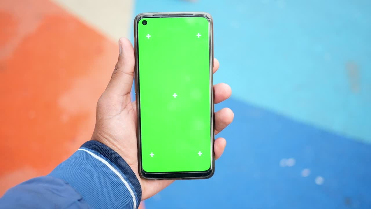 persona que sostiene un teléfono inteligente con pantalla verde