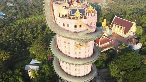 4k-Aerial-The-Wat-Samphran-Temple-with-huge-dragon-coiled-around-and-protecting-it-in-Amphoe-Sam-Phran-province-in-Bangkok,-Thailand