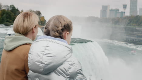 a woman with a child together admires the breathtaking spectacle of niagara falls