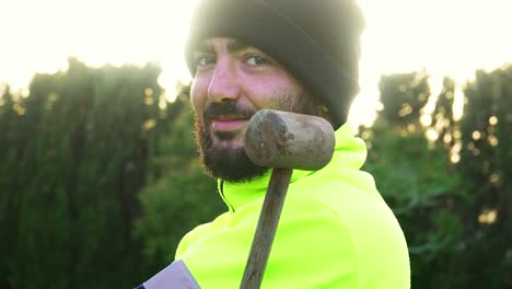 shot-of-a-worker-in-a-black-cap-and-reflective-jacket,-juggling-a-hammer