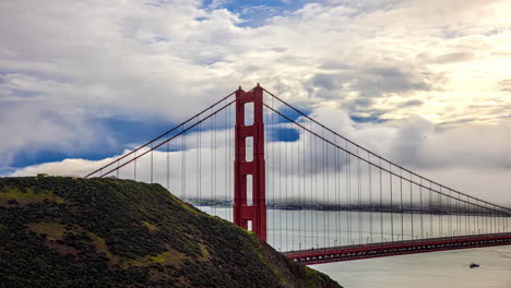 timelapse of traffic flow over iconic red golden gate bridge with low clouds