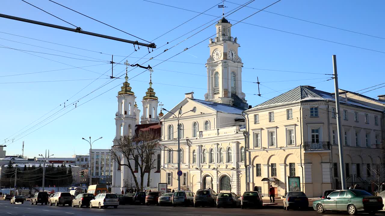 vitebsk, bielorrusia. tráfico en la calle lenina y el ayuntamiento en un soleado día de invierno