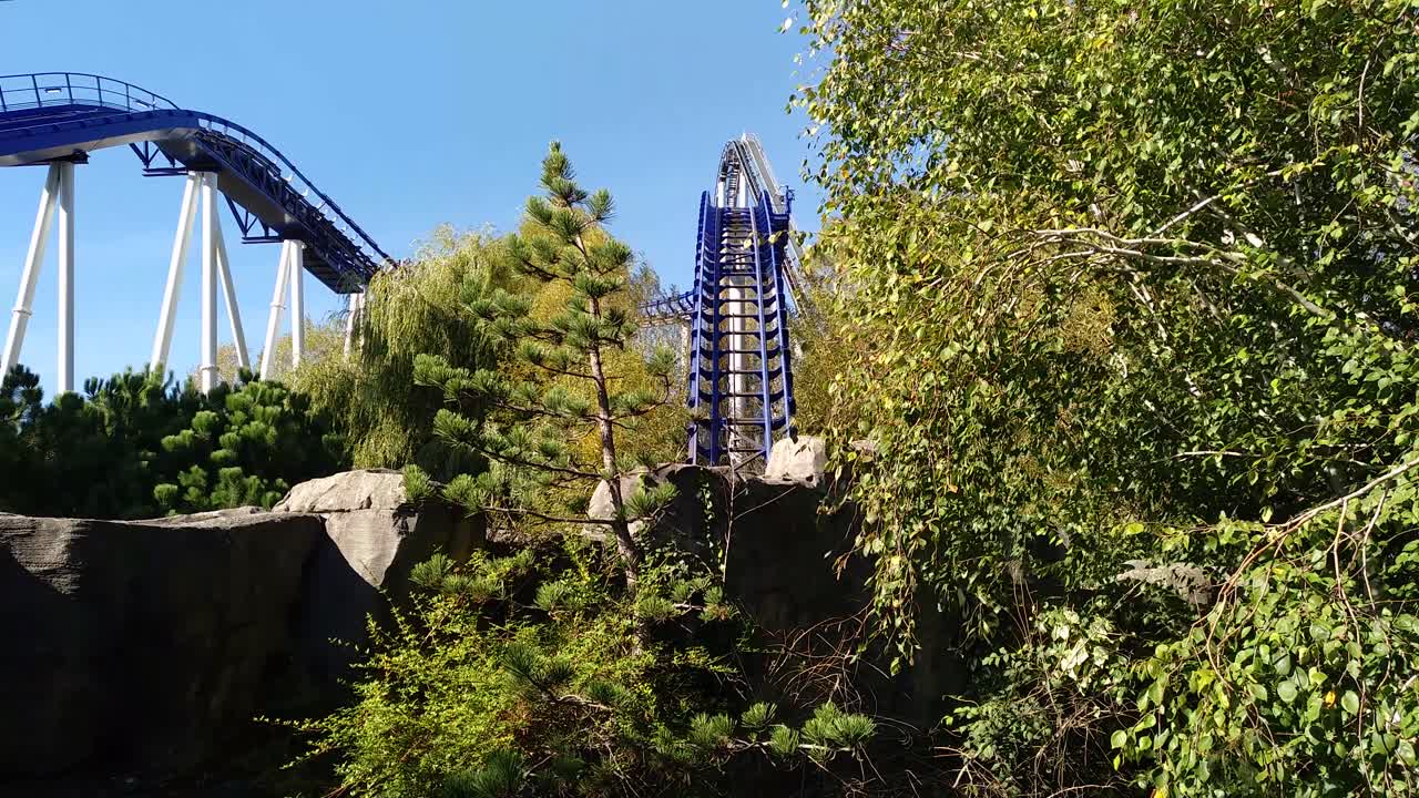 a roller coaster rides downwards in a theme park