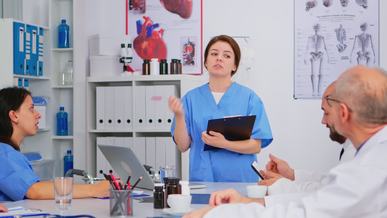 Equipe di medici che discute una diagnosi seduta a un tavolo in clinica.