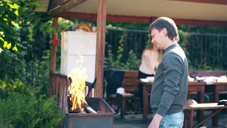 travelling young guy with a girl standing near the barbecue in which coals are smoking 1