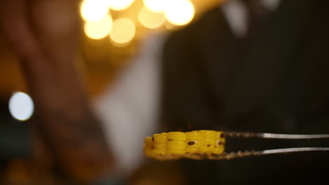 seasoning corn with spices, close-up shot of adding seasoning to a corn on the cob