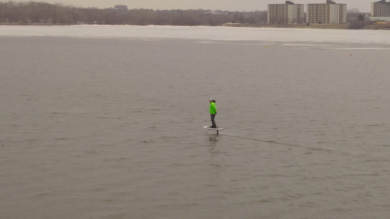 молодой человек катается на доске на подводных крыльях