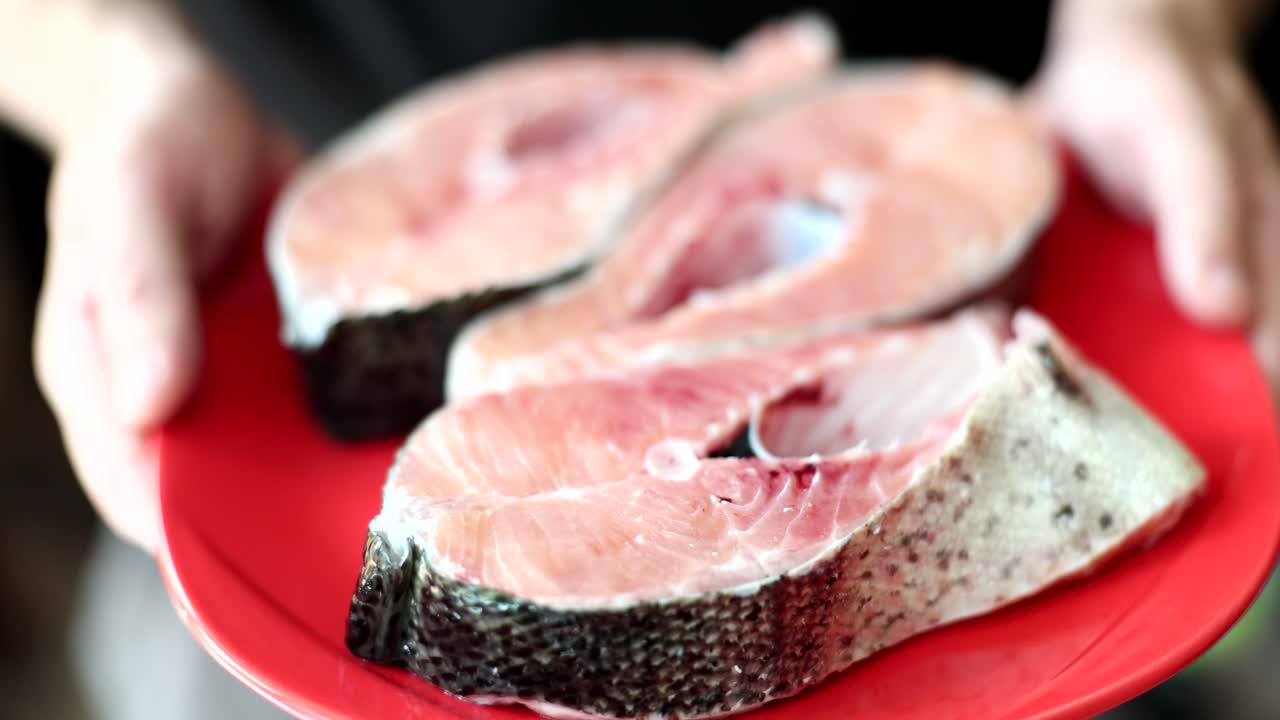 Raw Salmon Steaks on a Red Plate