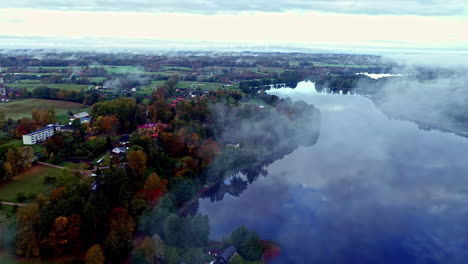 descripción general de drones temprano en la mañana con niebla flotando sobre aguas tranquilas del lago