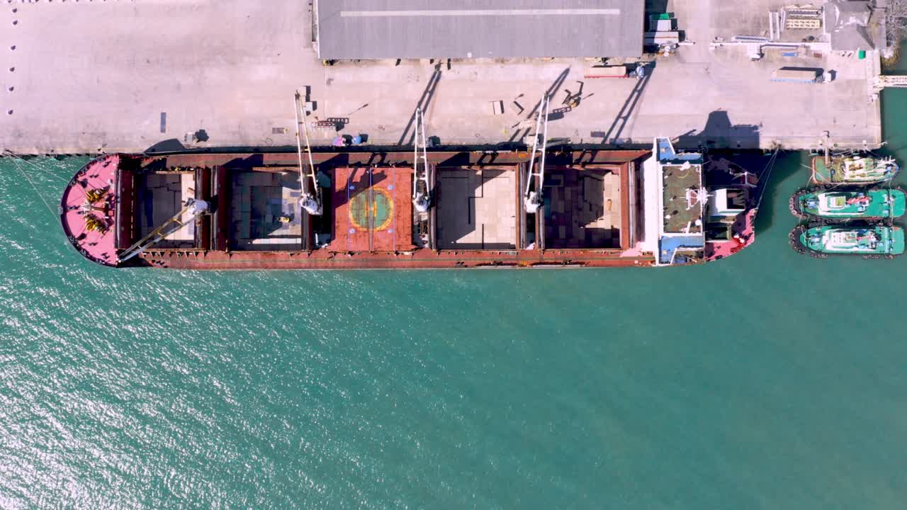 Aerial drone top view of containers cargo ship at industrial import-export port. Business logistic import and export freight transportation by container ship in open sea
