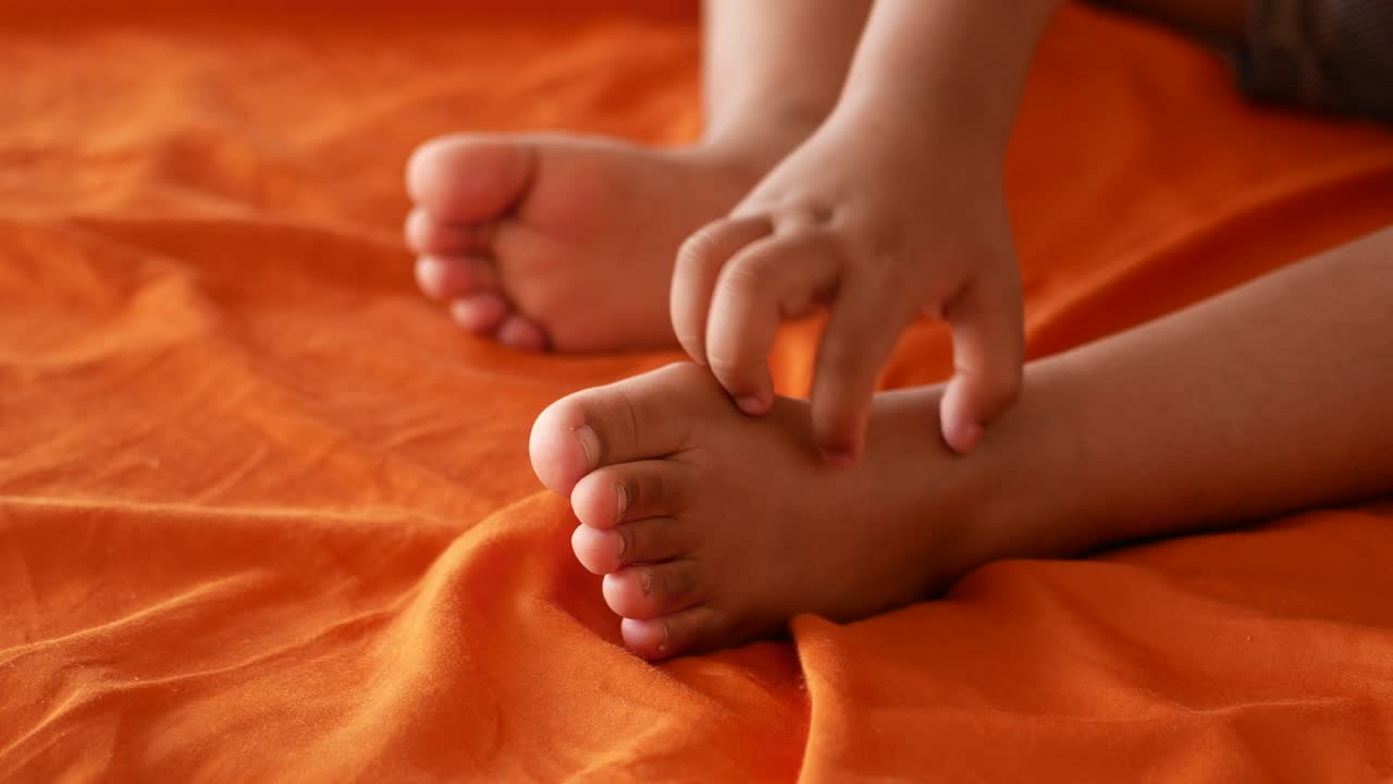 Child's feet on an orange blanket