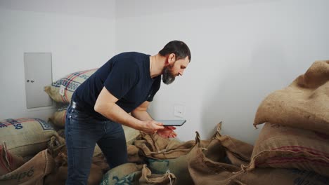 man inspecting coffee bags in a warehouse