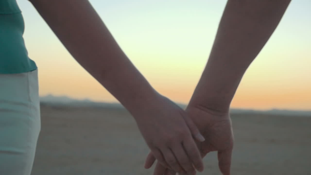 해가 지면 사랑하는 커플이 손을 잡고