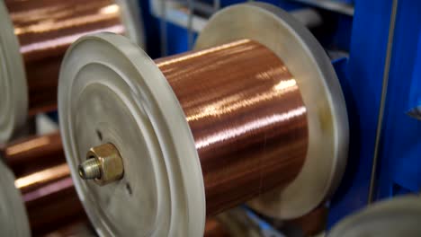 the process of drawing copper wires in the cable plant. coil with copper wire rotated on specialized equipment.