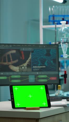 vertical video: chemists testing virus evolution with green screen tablet in front on desk
