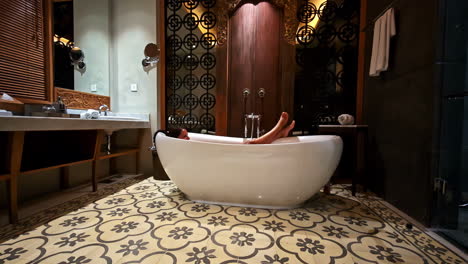a woman enjoys a peaceful bath in a high-end hotel bathroom at pantai berawa, bali