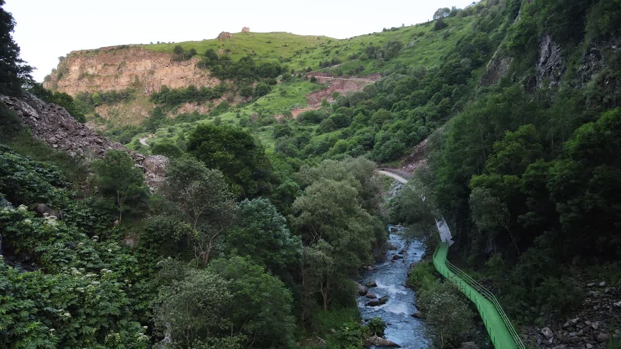 una vista cautivadora de un arroyo de montaña que fluye atravesando un valle exuberante y verde