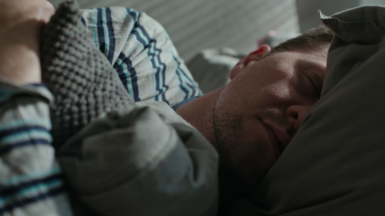 A sad man wakes up tired on his sofa