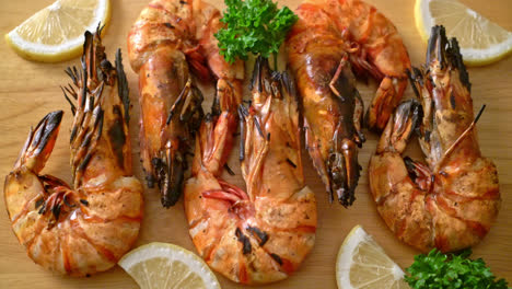 grilled tiger prawns or shrimps with lemon on wood board