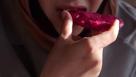 una mujer comiendo una galleta de remolacha