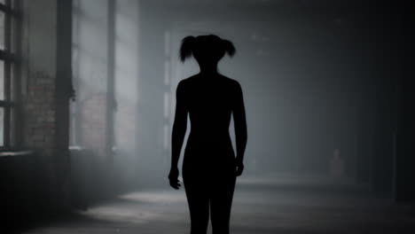 athletic woman walking in loft building. girl taking break between training