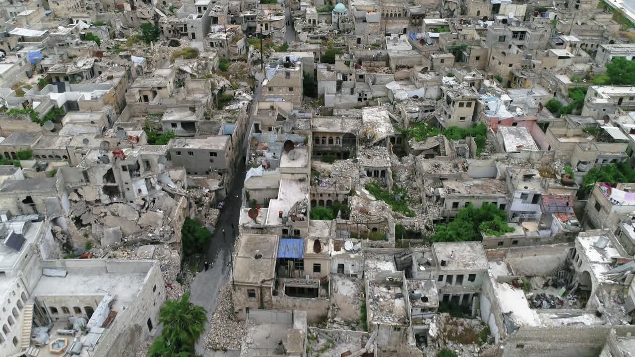 구름이 가득한 하늘 아래 알레포에 있는 집들의 공중 풍경: 전쟁 후 폐허가 된 시리아 도시의 건물과 집들을 볼 수 있다.