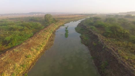 Drohnenschuss,-Der-Sich-An-Einem-Nebligen-Morgen-über-Einem-Fluss-Vorwärts-Bewegt-Und-Die-Reflexion-Des-Himmels-Auf-Dem-Fluss-Zeigt