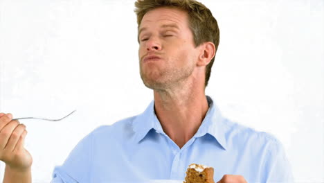 man savouring a delicious cake on white background