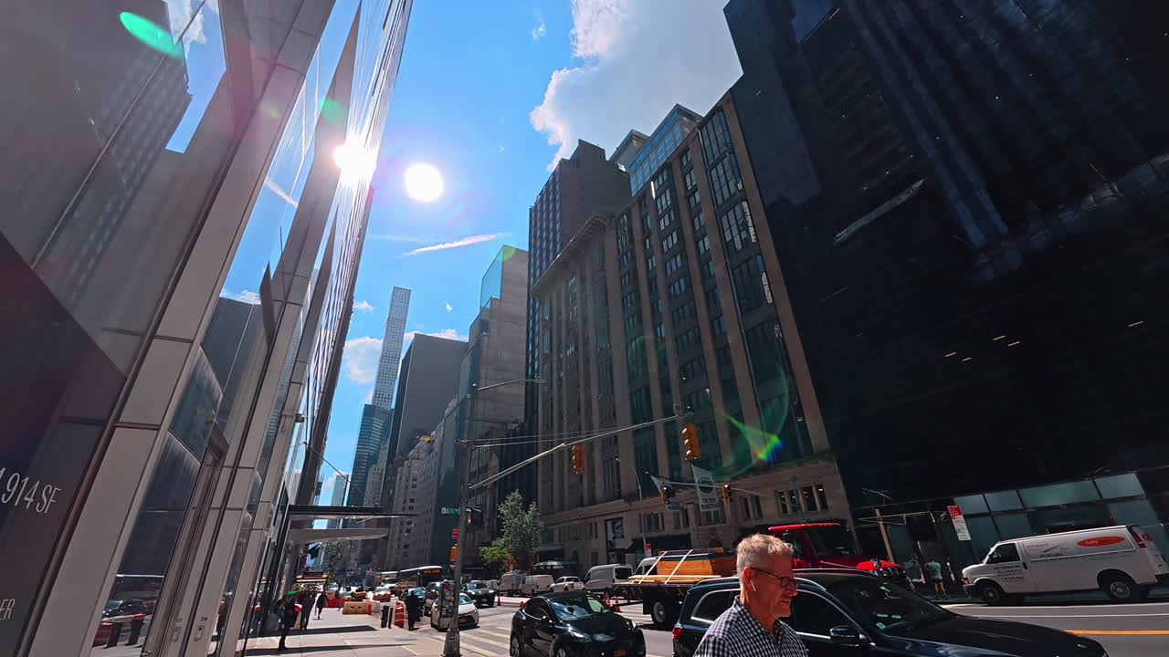 New York, USA, 1 agosto 2025: strada soleggiata di Manhattan con edifici alti. Grattacieli a Midtown Manhattan con auto e persone in una giornata luminosa e soleggiata