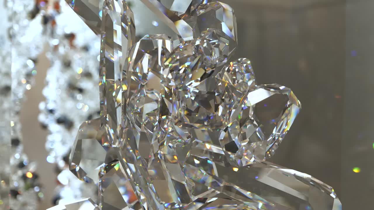 4k орбита вокруг сверкающей кристаллической скульптуры с яркими цветными огнями, отражающимися на ней с большим количеством кристаллов на заднем плане, видимых во время движения